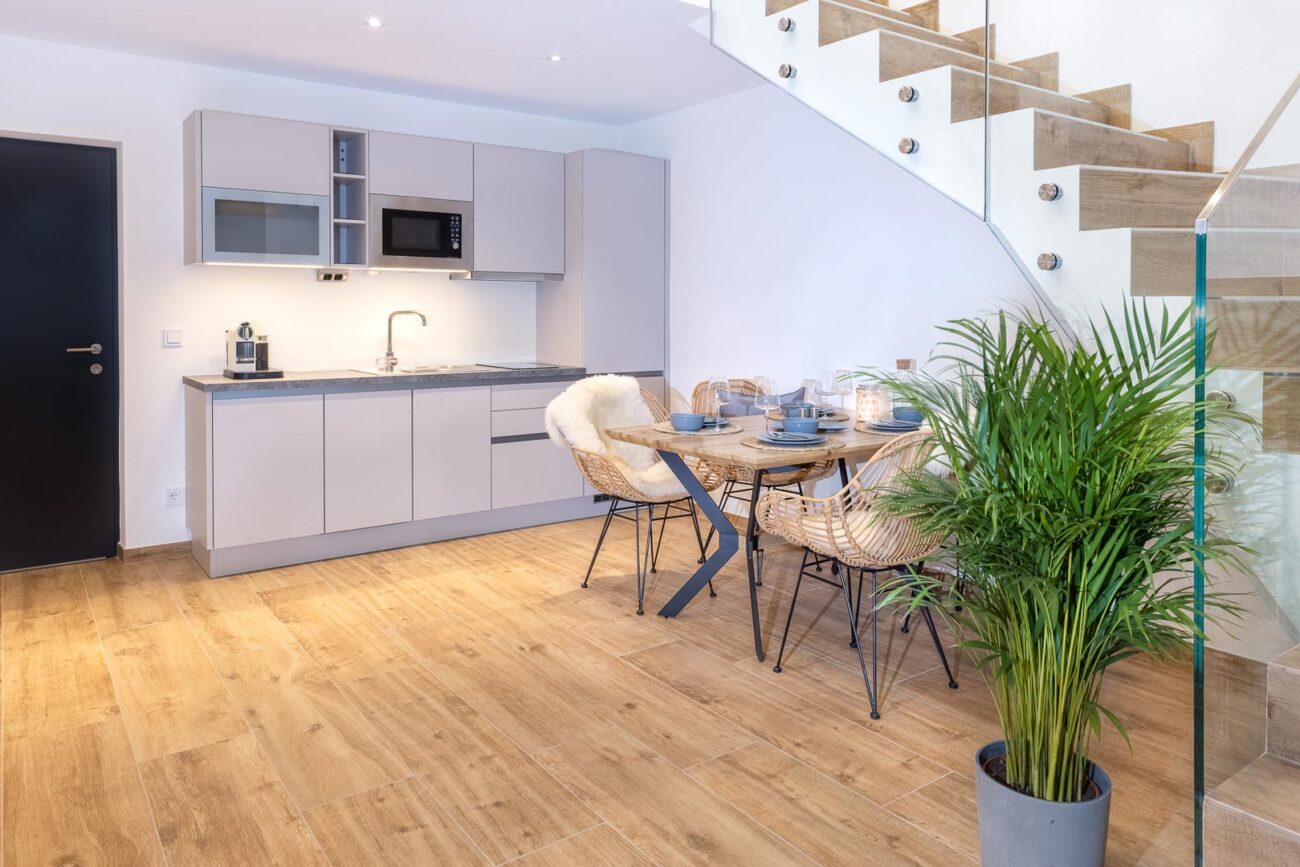 Appartment mit Kochnische und Esstisch. Schöner Eichenboden und Treppe in den ersten Stock rechts.