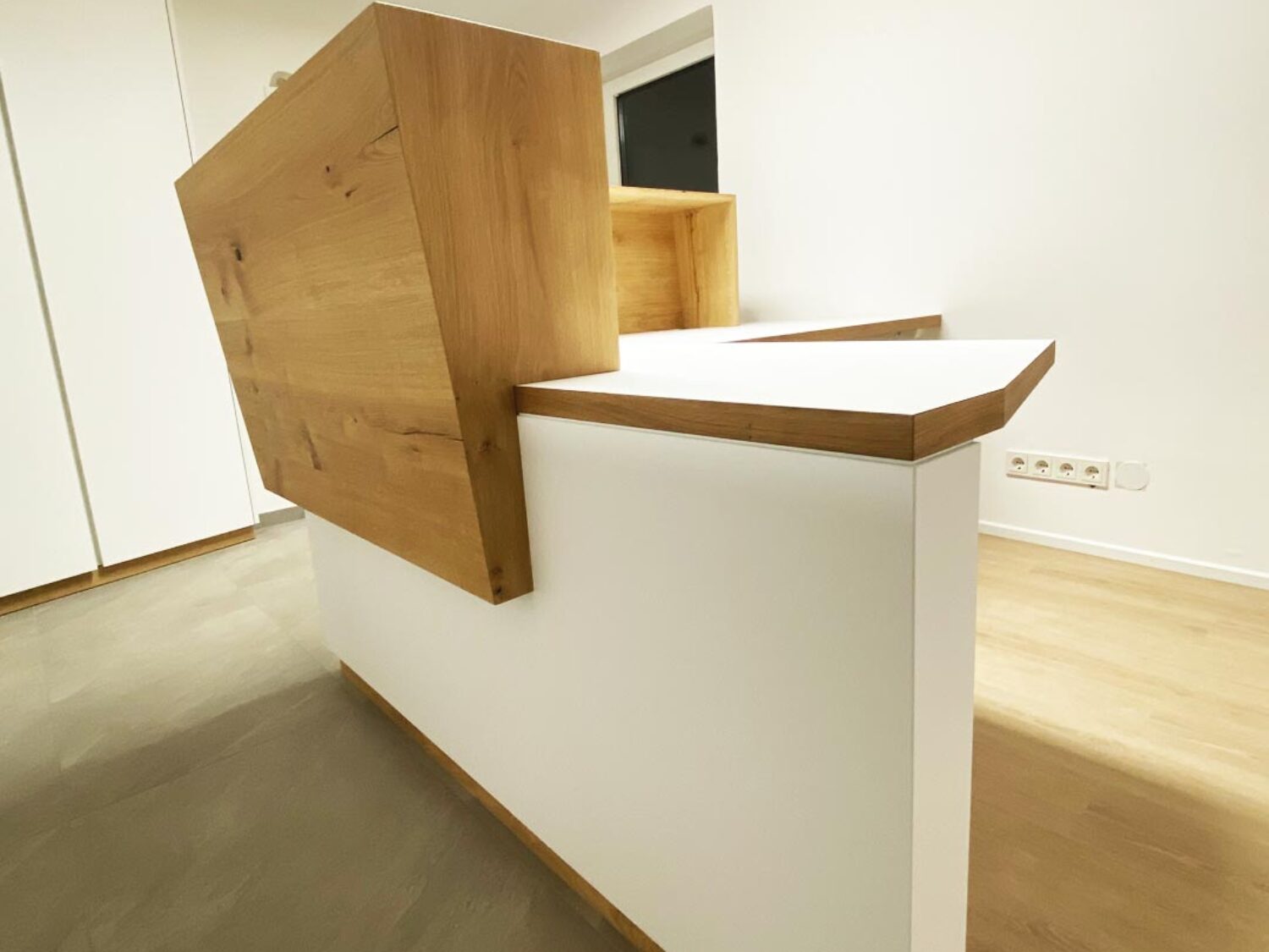 Extravaganter Empfangstisch Firma Flötzinger in Weiß und Holz.