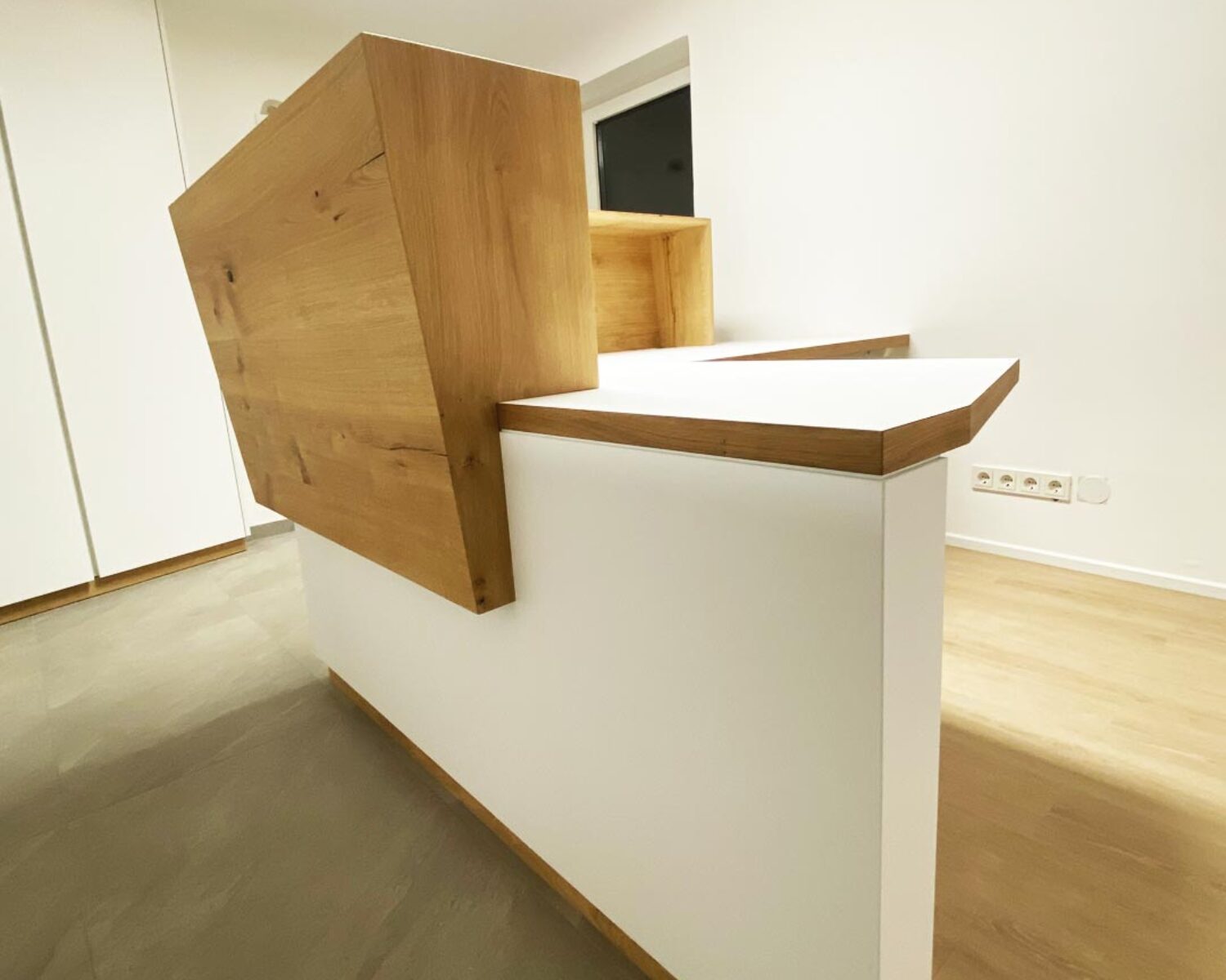 Extravaganter Empfangstisch Firma Flötzinger in Weiß und Holz.